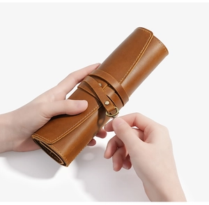 Macro detail of brown crazy horse leather roll pencil case with vintage metal ring closure
