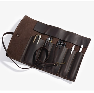 Detail of crazy horse leather roll-up pencil case with vintage key strap closure