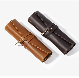 Macro detail of crazy horse leather pencil roll showing fine stitching and key charm