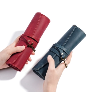 Handcrafted leather roll pencil case with vintage key charm in red and teal colors