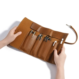 Vintage brown leather roll-up pencil case with six slots and secure strap closure