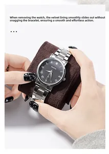 Detail of hand holding a steel quartz watch with silver Roman numerals on soft suede cushion