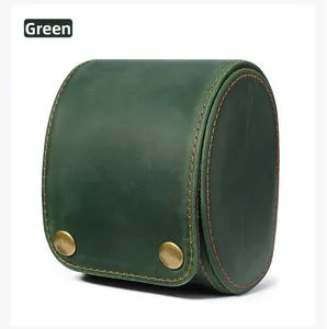 Macro view of green crazy horse leather watch pouch with orange stitching and brass snaps