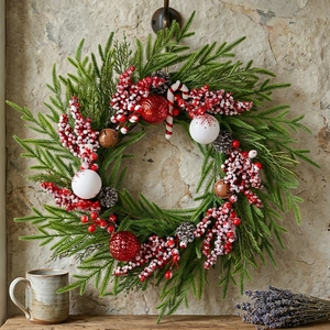Weihnachtskranz mit Tannenzapfen und Beeren sowie rot gestreiften Zuckerstangen Dekor