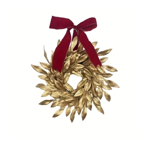 Christmas gold leaf wreath with large red velvet bow for festive home front door decoration