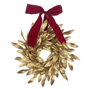 Christmas gold leaf wreath with a deep red velvet bow for festive home front door decoration