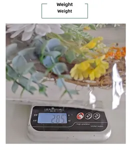 Artificial flower wreath weighing 285g on a scale for accurate shipping weight detail