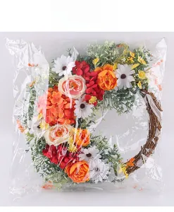 Detail of colorful artificial flower wreath with silk roses and peonies on natural rattan base