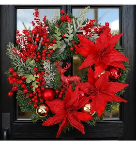 Detail of Christmas wreath with red poinsettia, reindeer, pine needles and gold baubles