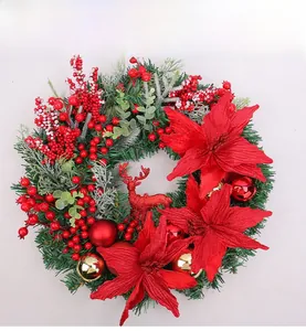 Detailed view of Christmas wreath featuring red poinsettias, pine needles and a glittery deer