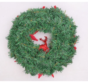 Close-up of artificial pine needles and red sequined reindeer on Christmas wreath