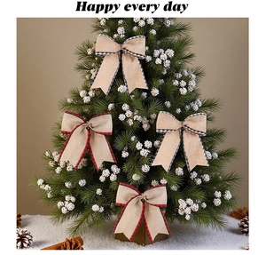 Detail of rustic burlap Christmas bows with red and black plaid edges on a pine tree