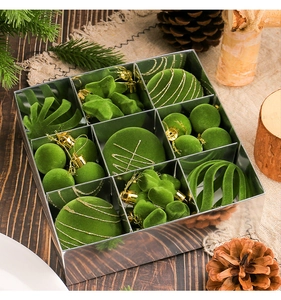 Flat lay of green flocked Christmas ornaments in a silver mirrored grid storage box