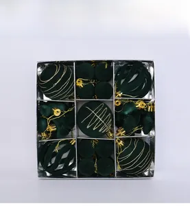 Detailed set of dark green flocked Christmas balls and bows with gold glitter in box