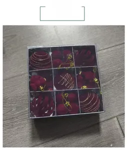 Detail of dark red Christmas ball ornaments set in transparent grid packaging box