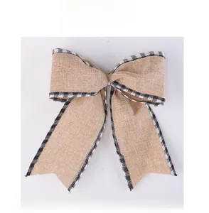 Detailed view of burlap Christmas bow with black and white plaid wired edges on white background