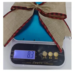 Close-up of a rustic burlap Christmas bow showing a weight of 8.3g on a scale