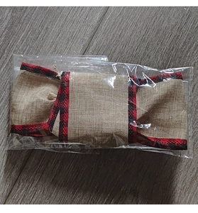 Detail of DIY burlap Christmas bow with red and black buffalo plaid trim in packaging