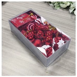 Detail view of red and white Christmas ornaments set in a clear gift box with candy cane shapes