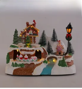 Detailed resin Christmas village featuring gingerbread house, lit street lamps, and snowy trees