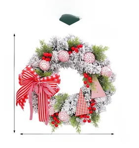 Detail of Christmas wreath with red berries, striped bow, and white flocked pine needles