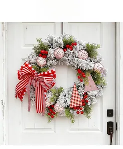 Detail of Christmas wreath with red berries and bow hanging on white wooden door
