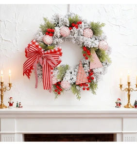 Detailed Christmas wreath featuring red berries and a large bow over a white fireplace