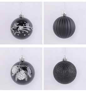 Detail of four black Christmas baubles featuring matte, glitter, and hand-painted star patterns