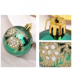 Detail of emerald green Christmas ball with gold glitter leaf patterns and hanging cap