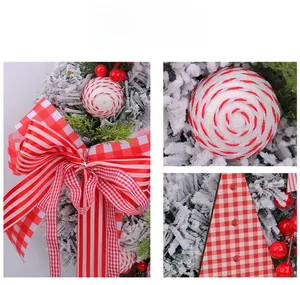 Detail of Christmas wreath with buffalo plaid bow, red berries and snow-flocked pine needles