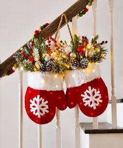 Couronnes gants de Noël lumineux avec pommes de pin et baies sur un escalier
