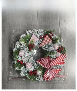 Christmas wreath with flocked pine needles, red berries, and checkered bow in retail packaging