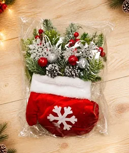 Détail d'un sac cadeau gant de Noël en velours rouge avec flocons et décoration