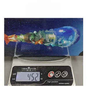 Luminous 3D crystal Christmas tree music box ornament on digital scale showing weight