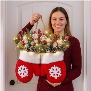 Verlichte kerstwant decoratie met dennenappels, rode bessen en warme LED-verlichting