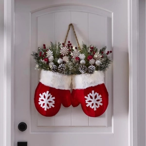 Kerstkrans met rode pluche handschoenen, dennenappels, bessen en witte sneeuwvlokken