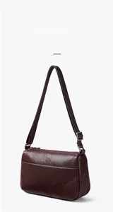 Detailed close-up of dark brown vegetable-tanned leather texture and metal zipper