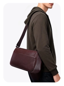 Side view of dark burgundy leather crossbody bag with adjustable shoulder strap