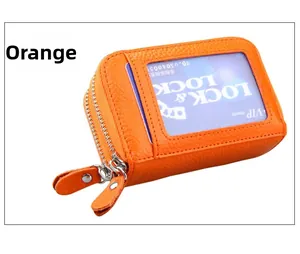 Détail du porte-cartes orange en cuir grainé avec double zip et fenêtre d'identité