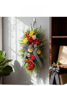 Detailed view of artificial rose swag with a black and white striped bow for home decor