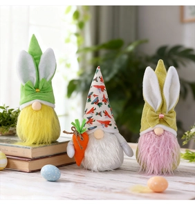 Détail de trois nains de Pâques en peluche colorés avec oreilles de lapin et carottes
