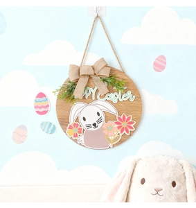 Détail de la suspension de porte en bois Joyeuses Pâques avec nœud en lin et verdure