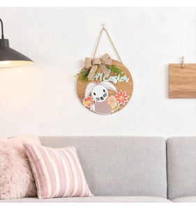 Détail de la couronne de Pâques en bois avec motif lapin et fleurs sur un mur blanc