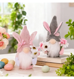 Détail de deux gnomes de Pâques avec oreilles à pois et bouquet de fleurs sur table en bois