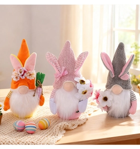 Trois gnomes de Pâques avec oreilles de lapin et carottes sur une table en bois décorée