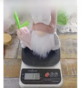 Détail du poids d'un gnome de Pâques rose tenant une carotte sur une balance numérique