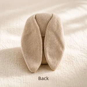 Dettaglio del retro dell'orecchio di coniglio in maglia beige con trama di filato screziato
