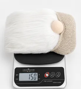 Gnomo di peluche pasquale del peso di 150g su una bilancia digitale imballata