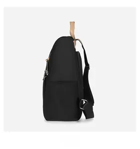 Side view of black nylon backpack showing side pocket and light brown leather handle