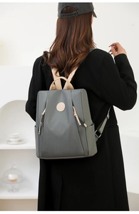 Rear view of a model wearing a green nylon anti-theft backpack with khaki straps